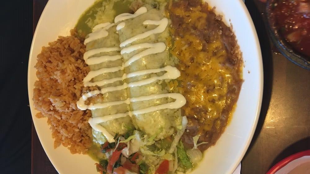 Enchiladas Suizas · Two corn tortillas filled with chicken, green onions, roasted mushrooms, green tomatillo sauce and cheese. Served with sour cream and salsa fresca.