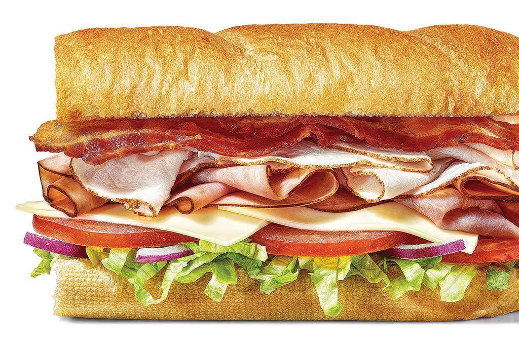 All-American Club® · The All-American Club® is a delicious combo of oven roasted turkey, Black Forest ham and hickory smoked bacon. We top it off with American cheese, lettuce, tomatoes and red onions on tasty, toasted Artisan Italian bread..