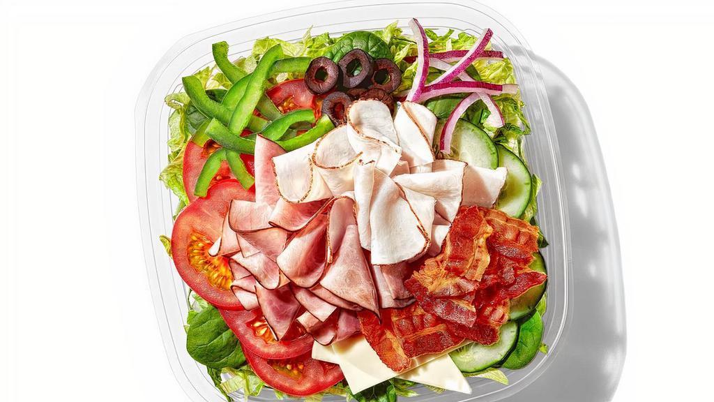All-American Club® (230 Cals) · Our classic All-American Club® is now a classic salad, too. Oven roasted turkey, Black Forest ham, hickory smoked bacon are the leaders of this club. Then we add American cheese and crisp lettuce, baby spinach, tomatoes, cucumbers, green peppers, red onions and black olives.