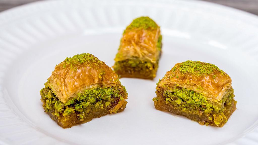 Baklava · Golden brown filo dough with a layer of pistachios. topped with syrup.