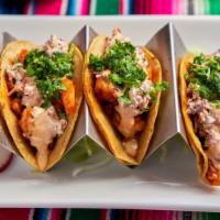 Piñata Shrimp Tacos · Three shrimp tacos topped with fresh sliced seasoned cabbage slaw and a delicious homemade c...