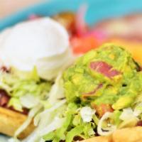 Sopes · Corn masa cake topped with refried beans, lettuce, sour cream, guacamole & your choice of me...