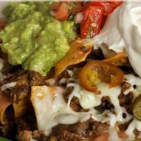 Nachos · Tortilla chips topped with beans, monterey jack cheese, jalapeño, guacamole and sour cream.