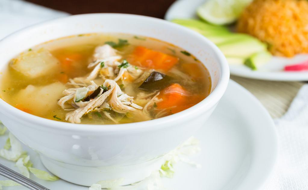 Caldo de Pollo / Chicken Soup · Homemade chicken soup with all white chicken meat & vegetables. Topped with avocado chunks, cilantro & onion. Served with a side of rice.