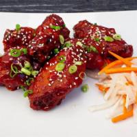 Korean Chicken Wings · Korean style spicy, crispy and savory chicken wings served with pickled daikon radish and ca...