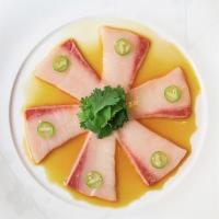 Yellowtail Jalapeno · Yellowtail sashimi served with yuzu soy sauce, sliced jalapeño, garlic, & cilantro. Consumin...