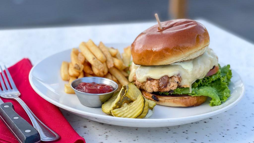Jam'n Salmon Burger · fresh salmon ground in-house then perfectly seared + our bacon jam, swiss, lettuce, tomato, buttery brioche bun and choice of side