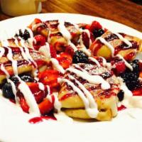 Blintzes with Fresh Berries · Our own special ricotta cheese filled blintzes, crepes covered with fresh berries, with rasp...