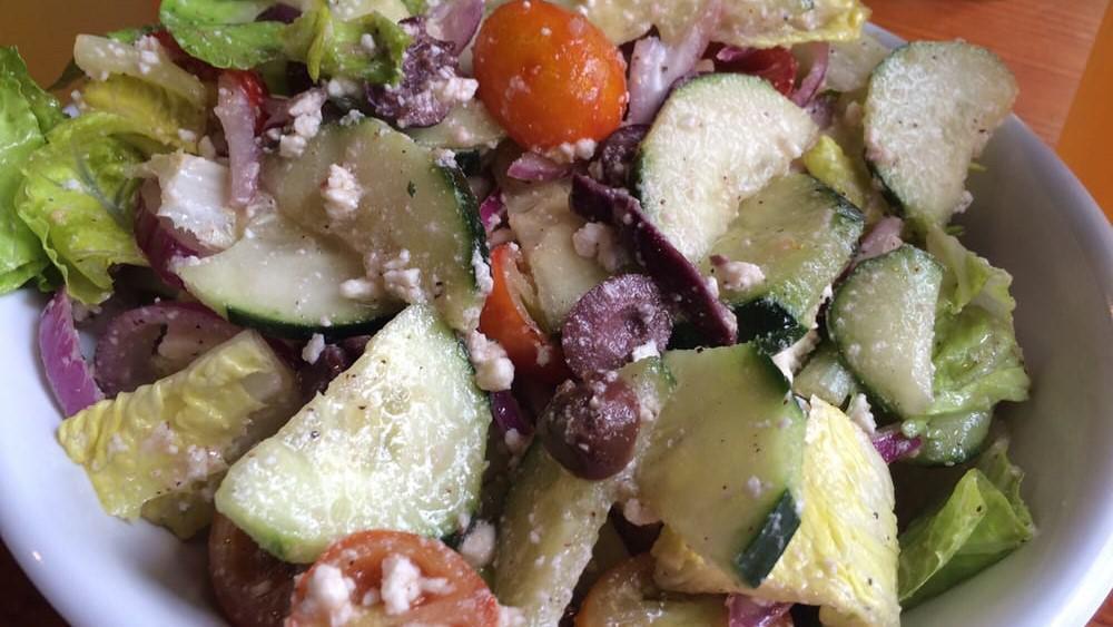 Greek Salad · Romaine lettuce, cucumber, cherry tomatoes, red onion and kalamata olives. Tossed in our house dressing and topped with feta cheese.