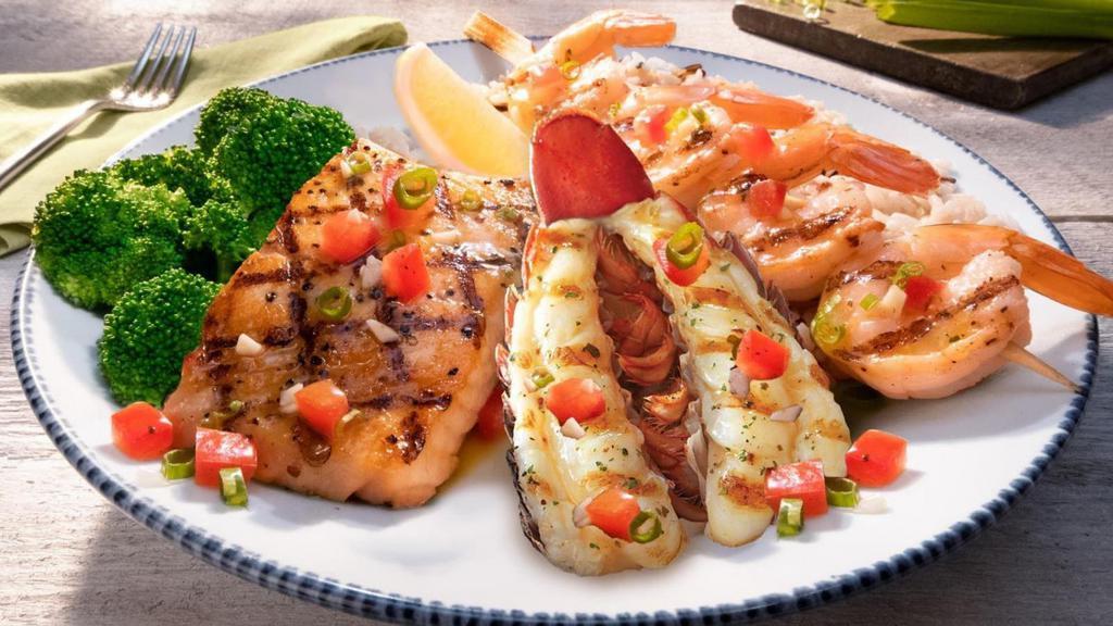 Lobster, Shrimp And Salmon** · A Maine lobster tail, jumbo shrimp skewer and fresh Atlantic salmon finished with a brown butter sauce. Served with choice of two sides.. 710 Cal