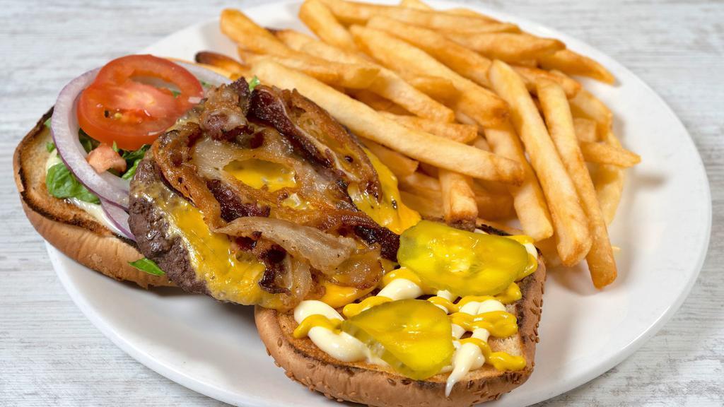 Bacon Cheeseburger · Hearty angus beef patty with creamy cheese, crispy bacon loaded onto toasted buns, served with French fries.