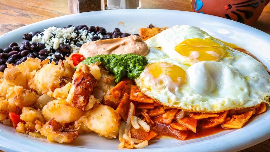 Chilaquiles · Corn tortilla chips cooked in a medium green tomatillo sauce or red spicy chile sauce, topped with two eggs, served with potatoes and choice of beans.