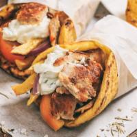 Chicken Shawarma Sandwich · Chicken shawarma, hummus, tahini, tzatziki, red onions, hot sauce, lettuce, sour red cabbage