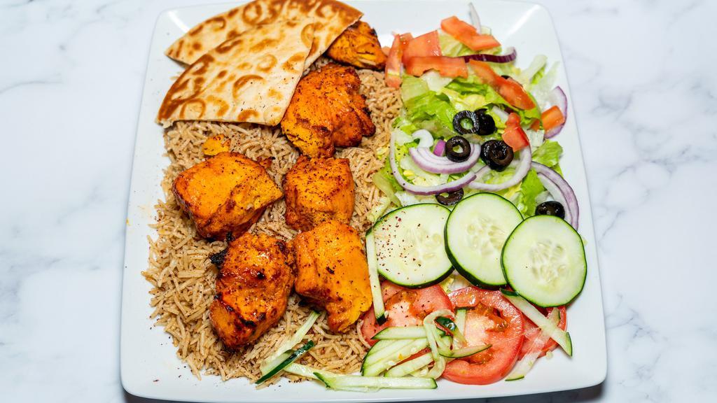 Chicken kabob · seasoned daily and cooked fresh daily. Lemon charbroiled chicken breast chunks lying on a bed of basmati rice. Comes with a house salad.
