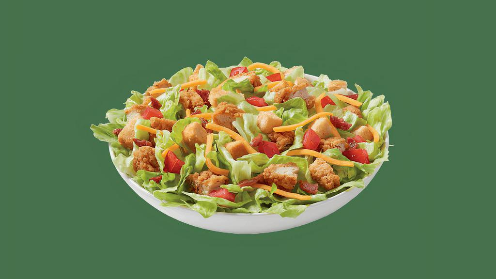 Crispy Chicken Strips Salad Bowl · 100% all-tenderloin white meat crispy chicken strips served on top of a crisp bed of lettuce, diced tomatoes, bacon, and shredded cheddar. Served with house-made Hidden Valley Ranch, or your choice of dressing. *Nutrition information does not include a dressing.
