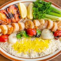Shrimp Kabob · One skewer of shrimp with rice, grilled tomato, bell peppers, and onions.