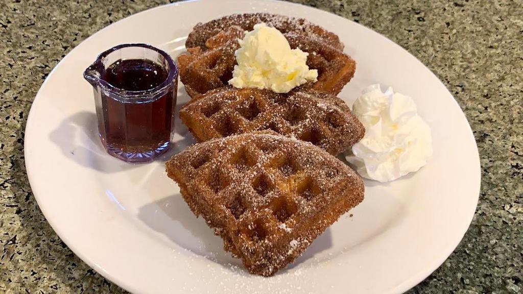 Churro Waffle · Our house made waffle deep fried and coated in cinnamon sugar. Sprinkled with powdered sugar and served with whipped cream, butter and syrup.