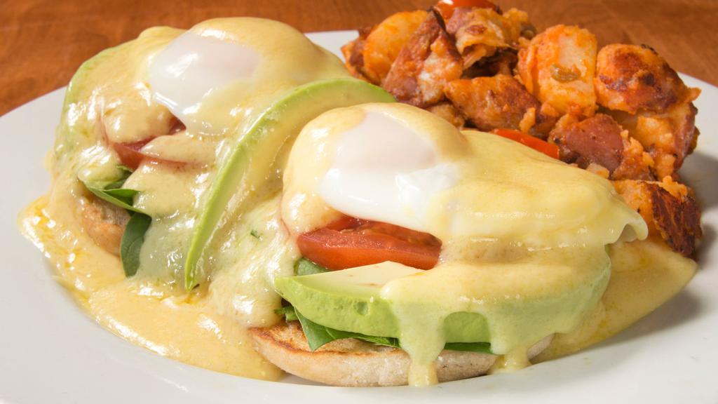 Vegetarian Benedict · Fresh grilled spinach, grilled tomatoes, and avocado on an English muffin topped with poached eggs and Hollandaise sauce.