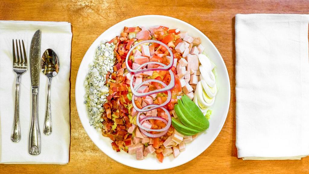 Cobb Salad · Iceberg lettuce, turkey, ham, tomatoes, avocado, bacon, crumbled blue cheese, red onion, and chopped eggs.