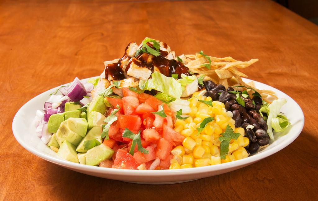 BBQ Chicken Tortilla Salad · Iceberg lettuce, chicken, corn, black beans, tomatoes, red onions, avocado, cilantro, BBQ sauce, and tortilla strips. Served with ranch dressing.