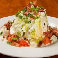 The Classic Iceberg Wedge · A wedge of iceberg lettuce topped with blue cheese dressing, extra blue cheese crumbles, cho...