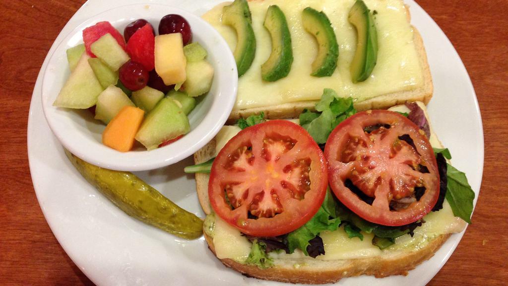 Avocado Melt · Sliced avocado and melted jack cheese on grilled sourdough bread with tomatoes, organic spring mix, and pesto mayonnaise. Served with fresh fruit.