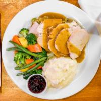 All American Turkey Dinner · Hand carved slow roasted turkey breast topped with gravy, served with a cornbread sage stuff...