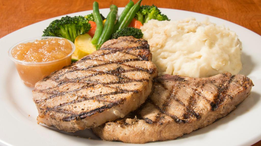 Pork Chops · Juicy center cut pork chops, served with real garlic mashed potatoes, fresh vegetables, and cinnamon applesauce.