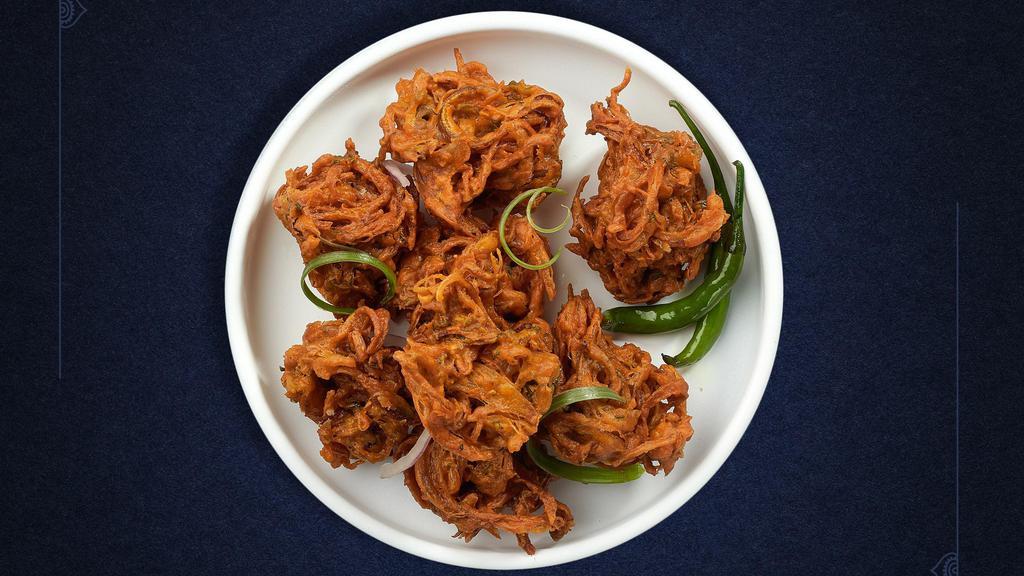 Onion Pakora · Assorted vegetables dipped in a light batter and fried until golden brown.