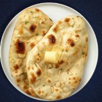 Great Garlic Naan · Freshly baked bread in a clay oven garnished with garlic and butter.
