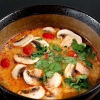 Tom Yum Goong · Spicy and sour lightly creamy soup with shrimp, mushroom and cilantro.