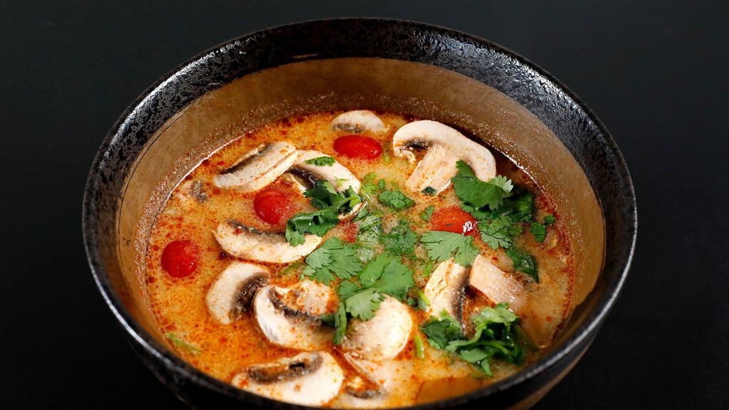 Tom Yum Goong · Spicy and sour lightly creamy soup with shrimp, mushroom and cilantro.