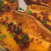 Potato Skins · A Meal In Itself. Cheddar Cheese, Bacon, & Green Onions.