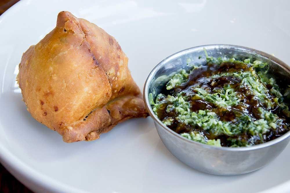 Samosa (1) · A single crunchy savory pastry stuffed with spicy potatoes and peas. Served with zingy cilantro and sweet tamarind chutneys. Vegan.