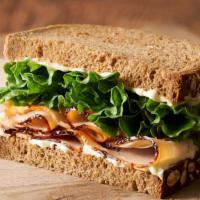 Tommy Turkey · Half of a turkey breast sandwich with lettuce and Erik’s Secret Goo on hearty 9-grain bread....