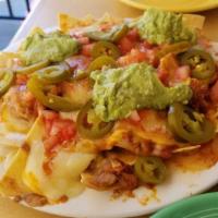 Nachos · A bed of home made tortilla chips layered with beans and melted cheeses. Topped with fernand...