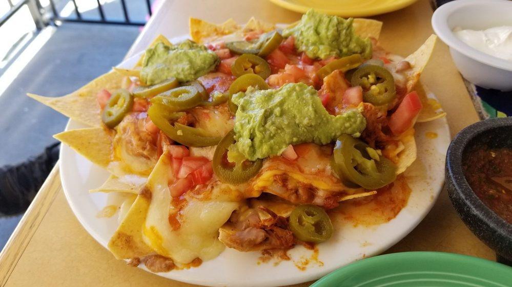 Nachos · A bed of home made tortilla chips layered with beans and melted cheeses. Topped with fernando's mild sauce, tomatoes and jalapenos.