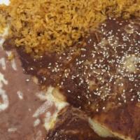 Mole Enchiladas · Two chicken enchiladas covered with melted jack cheese and mole sauce. Topped with raw onion...