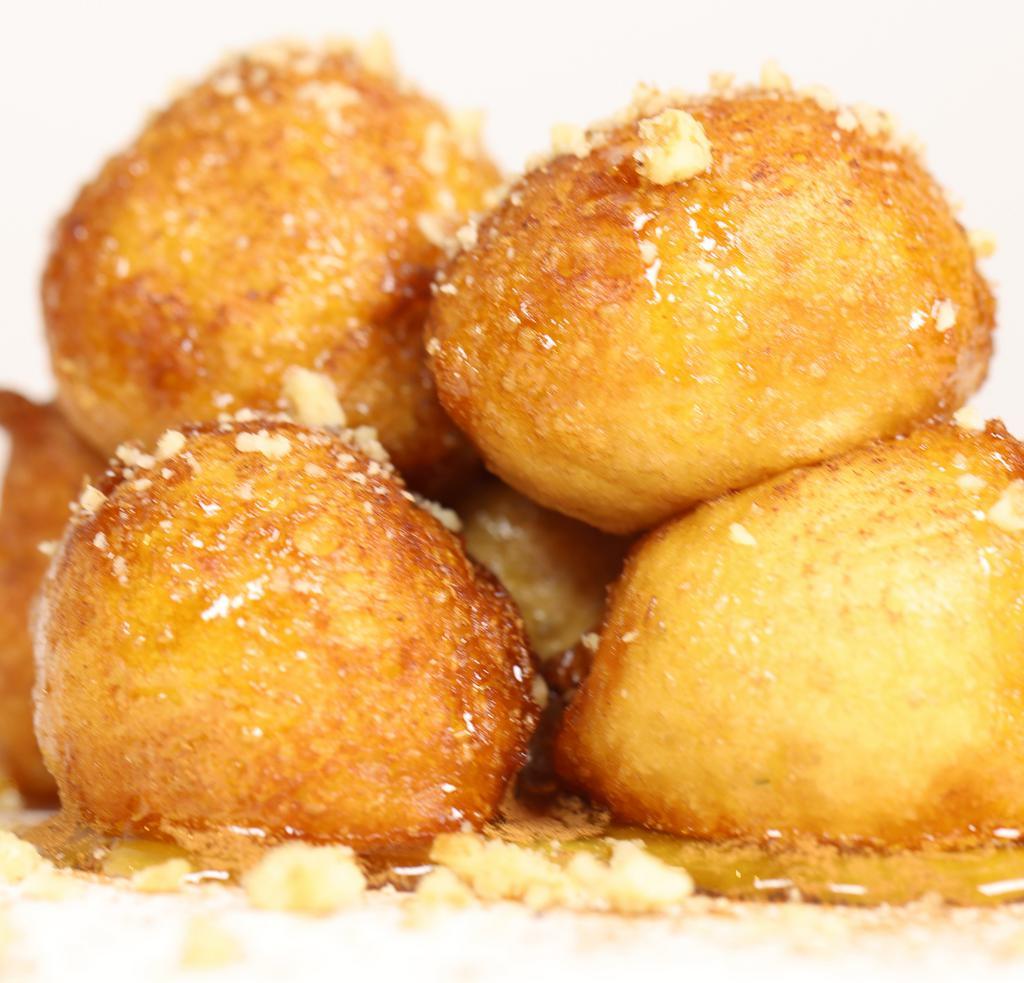 Loukoumades · Traditional Greek beignets, nuts and honey syrup.