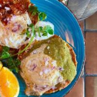 Huevos Rancheros · Two fried corn tortillas, refried beans, cheddar & jack cheese, eggs to style, red and green...