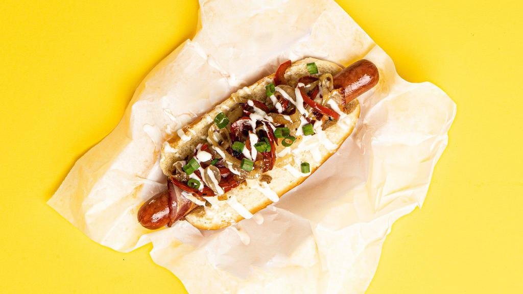 LA Dog · Bacon wrapped dog topped with sauteed onions and peppers, and sliced scallions, served on a fluffy bun.