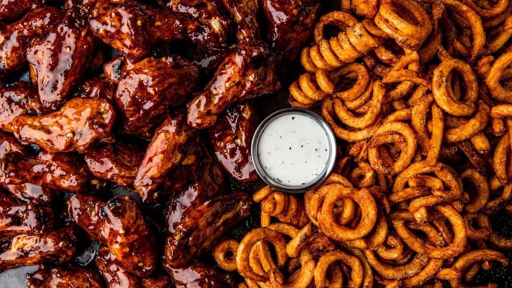 32 Bone-In Wings · 32 bone-in wings tossed in your choice of 4 flavors. Served with curly fries & a side of ranch
