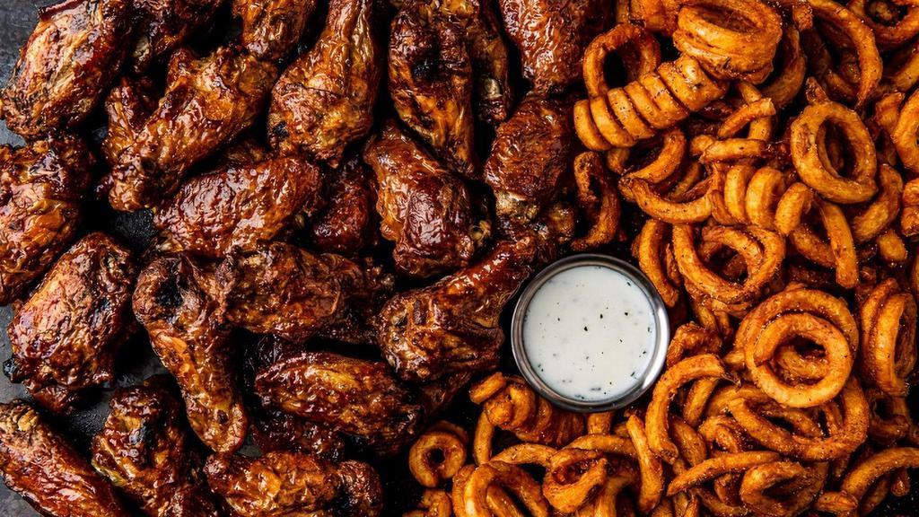 32 Smoked Bone-In Wings · 32 bone-in wings smoked in-house over pecan wood then tossed with your choice of 4 flavors. Served with curly fries and a side of ranch.