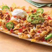Neighborhood Nachos With Chipotle Lime Chicken · Freshly made white corn tortilla chips are topped with grilled chicken, queso blanco, a blen...