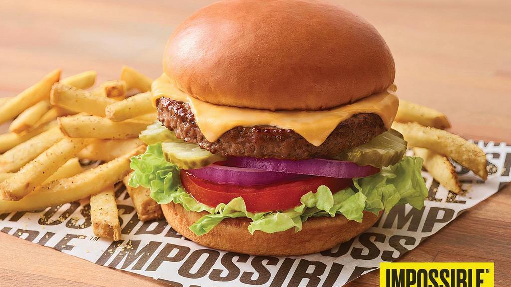 New Impossible™ Cheeseburger · A delicious Impossible™ Burger Made From Plants for those who crave meat topped with two slices of American cheese, lettuce, tomato, onion and pickles. Served with fries.