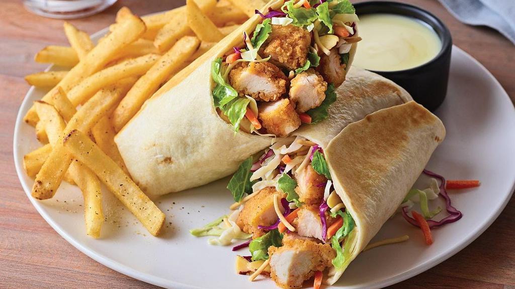 Oriental Chicken Salad Wrap · Our long-running favorite salad, all wrapped up. Crispy breaded chicken tenders with fresh Asian greens, crunchy rice noodles and almonds rolled up in a warm flour tortilla. Served with classic fries and Oriental vinaigrette on the side.