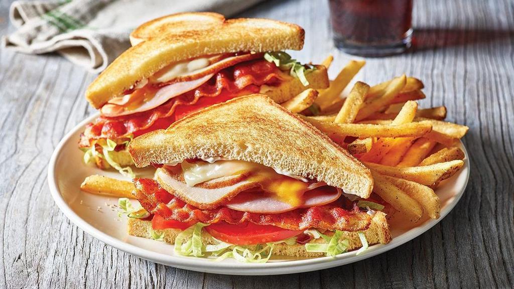 Clubhouse Grille ¥ · Sliced ham and turkey, Cheddar, Swiss, two strips of Applewood-smoked bacon, lettuce, tomato, mayo and honey BBQ sauce on toasted Potato bread.  Served with classic fries.