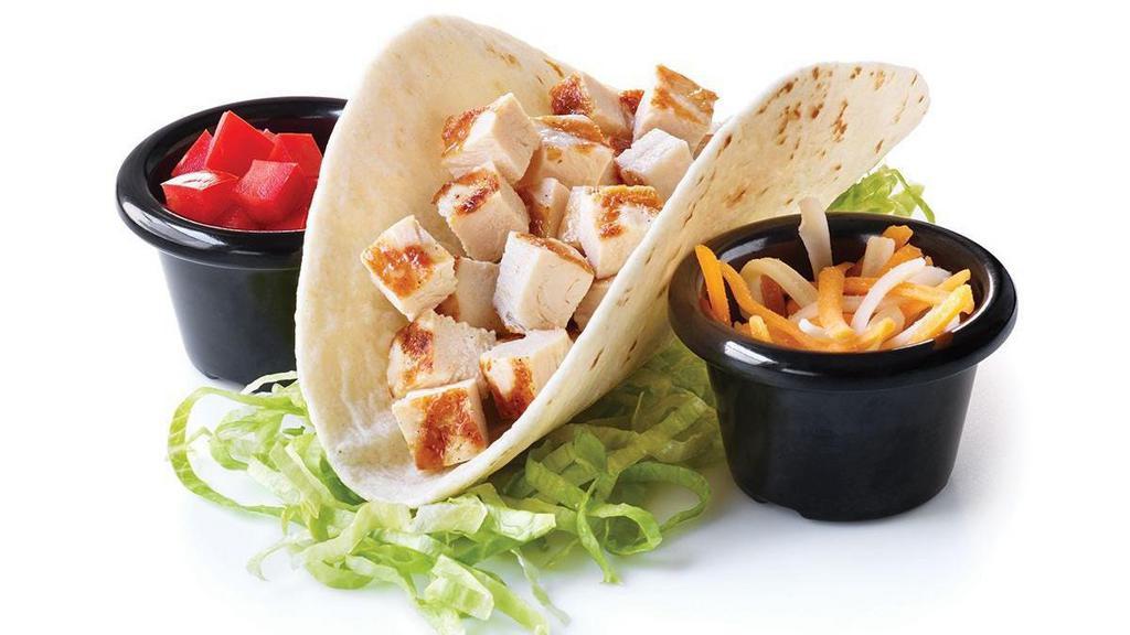 Chicken Taco · A soft flour tortilla shell filled with chopped chicken and Cheddar cheese. Served with lettuce and tomatoes. Taco ‘bout delicious!