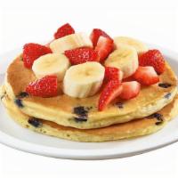 Stack Of Double Berry Banana Strawberry Pancakes  · Buttermilk pancakes cooked with blueberries and topped with fresh seasonal berries and banan...