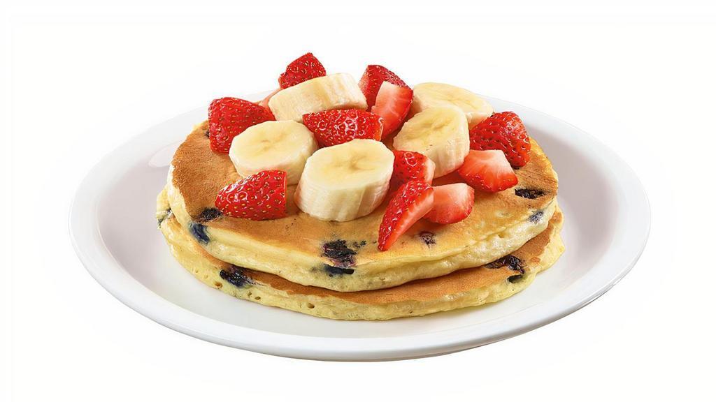 Stack Of Double Berry Banana Strawberry Pancakes  · Buttermilk pancakes cooked with blueberries and topped with fresh seasonal berries and bananas.